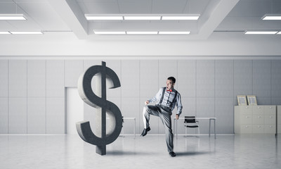 Determined banker man in modern office interior breaking dollar figure