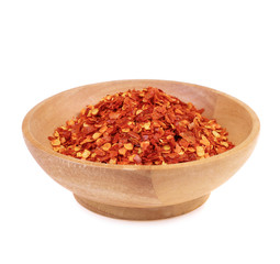 Dried red chili pepper flakes in wooden bowl isolate on white background