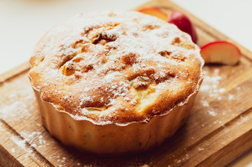 Pie on a wooden board sprinkled with icing sugar. Apple strudel. Curd Cupcake