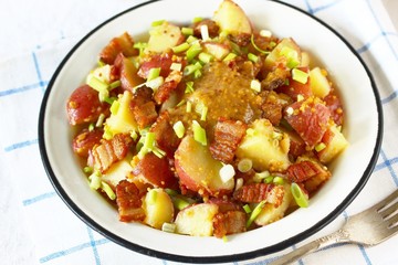 German potato salad with fried bacon and mustard dressing. traditional for oktoberfest festival.