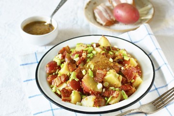German potato salad with fried bacon and mustard dressing. traditional for oktoberfest festival.