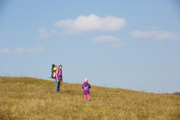 Mother with children hiking on a nice autumn day carrying kid