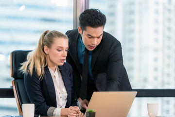 Business partners discussing graph of financial, two people are presented marketing work project to...