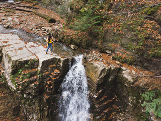 woman on the cliff looking at waterfall enjoying the view