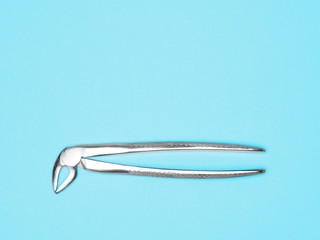 Dental surgical instrument on blue background. Dental care concept