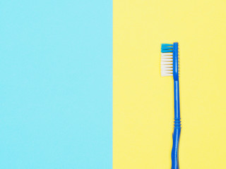 Toothbrush on yellow and blue background. Dental care concept
