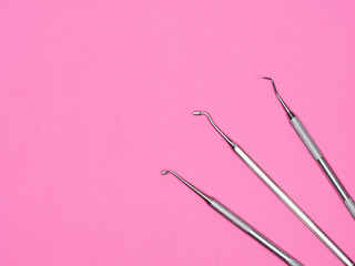 Dental instrument on pink background with copy space. Dental care concept