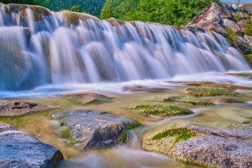 Mountain cold fresh water turquoise color of the Alpine mountains. Photo taken at long exposure.