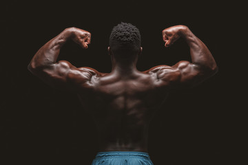 Athletic african american male bodybuilder flexing muscles