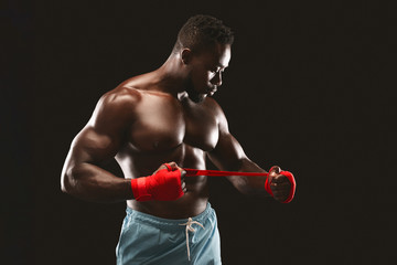 Fototapeta na wymiar Black young kickboxer getting ready for fight