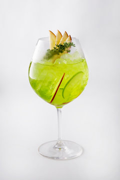 Apple Cocktail In a luxuriously shaped glass consisting of ice and sliced apples, decorated with green herbs Filmed on a white scene