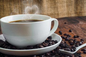 Cup of coffee on wooden table with smoke like a heart