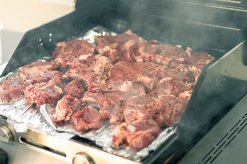 Cooking meat on the grill. The process of making grilled meat. Raw meat on the grill