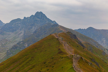 Fototapeta na wymiar Tourists walking along the ridges of the mountains in the Tatras