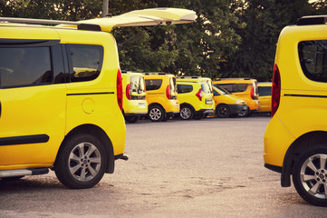 Parking yellow taxi cabs. Sunny day. Passenger transportation and transport.