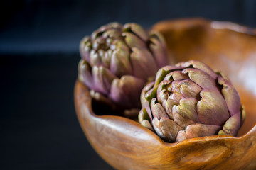 Basket of freshly picked artichokes resting on the kitchen table. Idea of healthy and country cooking. The concept of ecological product, healthy nutrition, harvest.
