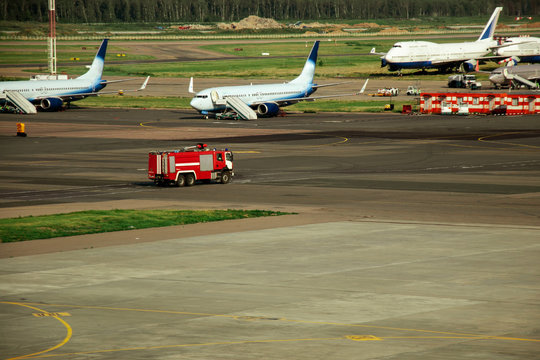 Fire truck on the runway near the aircraft. Airport Rescue Service. Firefighters and fire department at the airport. Crisis Response System.