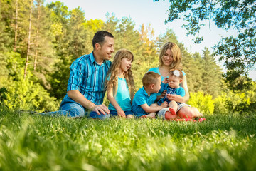 Naklejka na ściany i meble happy family outdoors in the park