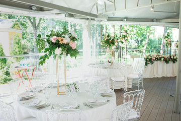Beautiful composition with flowers on the tables and candles for guests at a wedding or a birthday party