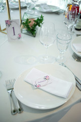 Beautiful composition with flowers on the tables and candles for guests at a wedding or a birthday party