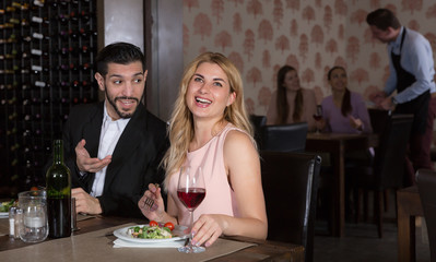 Adult couple on romantic date drinking red wine