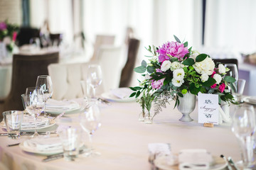 Beautiful composition with flowers on the tables and candles for guests at a wedding or a birthday party