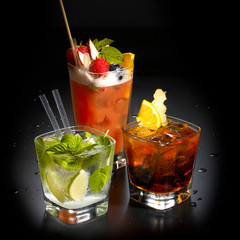 different types of cocktails in the appropriate glasses, fruit ice and straws, black background