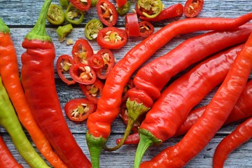 Close-up of sliced chili peppers on an old wooden surface, selective focus.