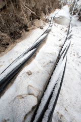 Laying a fiber optic and electricity cables in the frozen ground, buried cables for fast internet in rural region - underground cabling in Finland