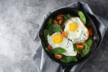 Fried egg on a pan served with fresh cherry tomatoes. Healthy breakfast.