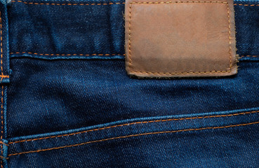 Naklejka premium Macro, Close-up of blank leather label on new denim blue jeans trousers. fashion and retro stlye on background.