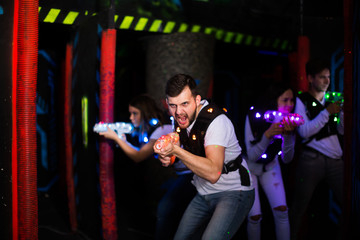 Obraz na płótnie Canvas Emotional guy playing laser tag