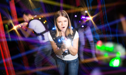 Female laser tag player in bright beams