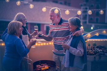 group of happy cheerful old senior people have fun together celebrating during dinner with barbecue...