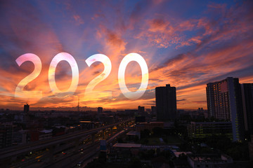 year 2020 text over sunrise sky of cityscape
