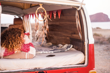 woman with curly hair and striped sweater sleeping and dreaming on home van, lulled by the sea...
