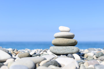 Fototapeta na wymiar balance of stones on the background of the sea on the pebble plan, the concept of harmony and relaxation