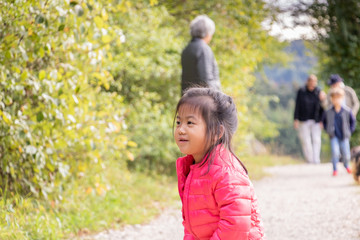 Petite fille eurasienne chinoise et française heureuse de sa ballade en famille dans la forêt à...