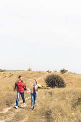 attractive woman with bouquet and handsome man smiling and holding hands