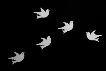 group of flying white doves on black background