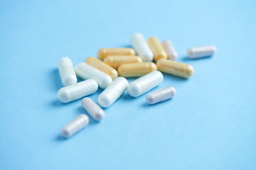 Vitamins and supplements on bright paper background. Concept for a healthy dietary supplementation. Close up. Copy space. 