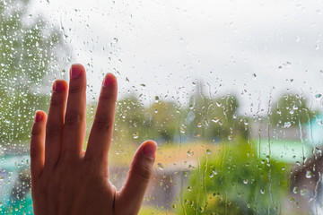 hand on the rainy glass close-up