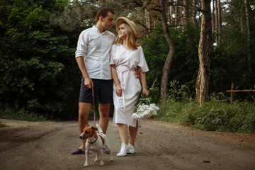 Fototapeta premium walk with your beloved in the forest, couple in love with a dog in nature