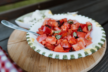 Mouthwatering tomato salad with Basil in a dish outdoor selective focus
