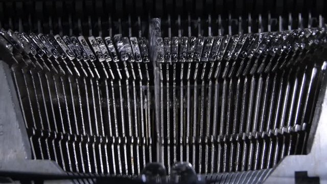 Letters hitting the paper while typing in an old qwerty typewriter