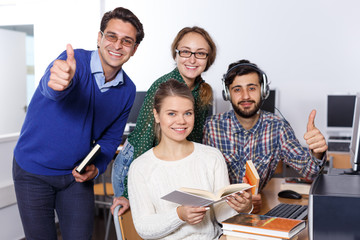Group portrait of smiling students reading books