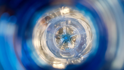 Long background with a plastic blue bottle with water drops inside