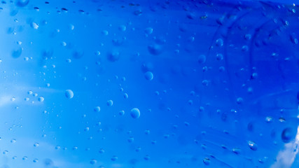 Naklejka na ściany i meble A lot of drops of water inside a plastic bottle. Blue background with water drops