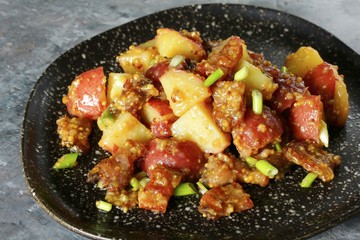 German potato salad with fried bacon and mustard dressing. traditional for oktoberfest festival.