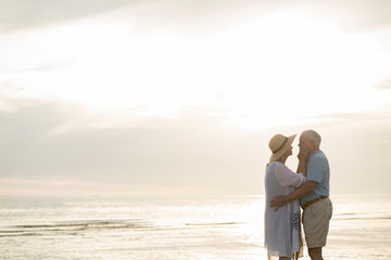 Senior couple standing face to face on the beach by sunset, Liepaja, Latvia